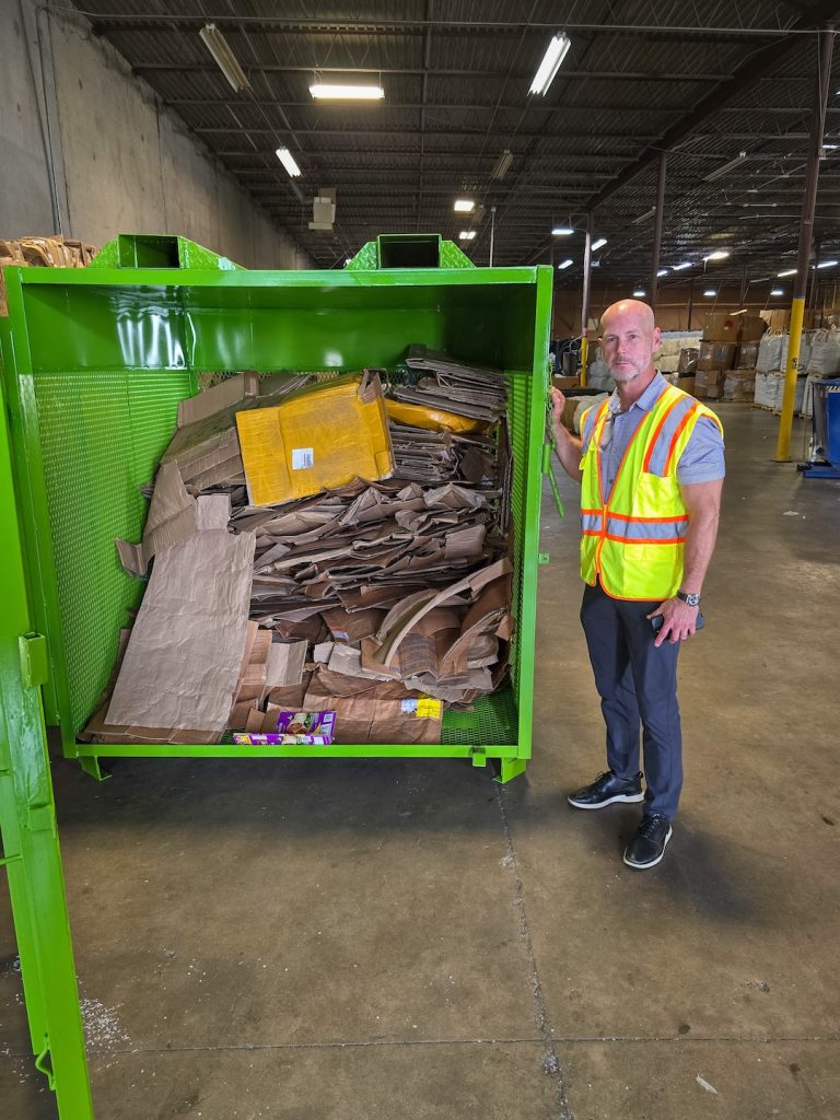 employee standing next to a cardboard cage